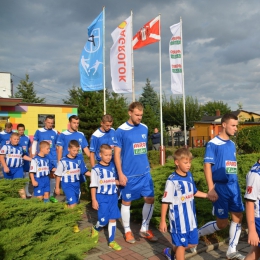 Zawodnicy z KS Piłkarz wyprowadzają piłkarzy z MKS Drwęca G-D na boisko
