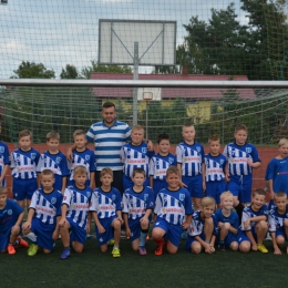 Zdjęcie młodych piłkarzy z trenerem Kamilem Nowatkowskim